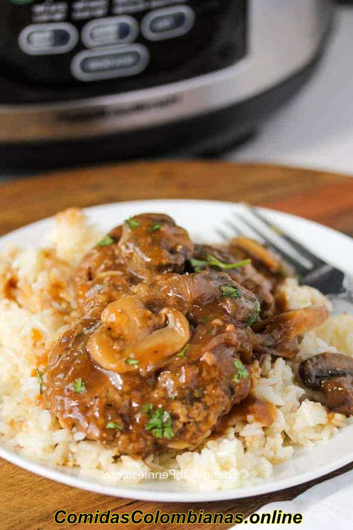 Crock Pot Salisbury Steak en un plato con arroz