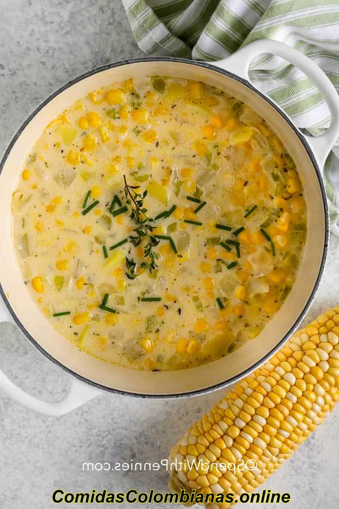 Sopa de maíz servida en un bol con pan al lado 