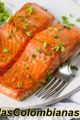 Filetes de salmón al horno con un tenedor en un plato cubierto con cebollas verdes