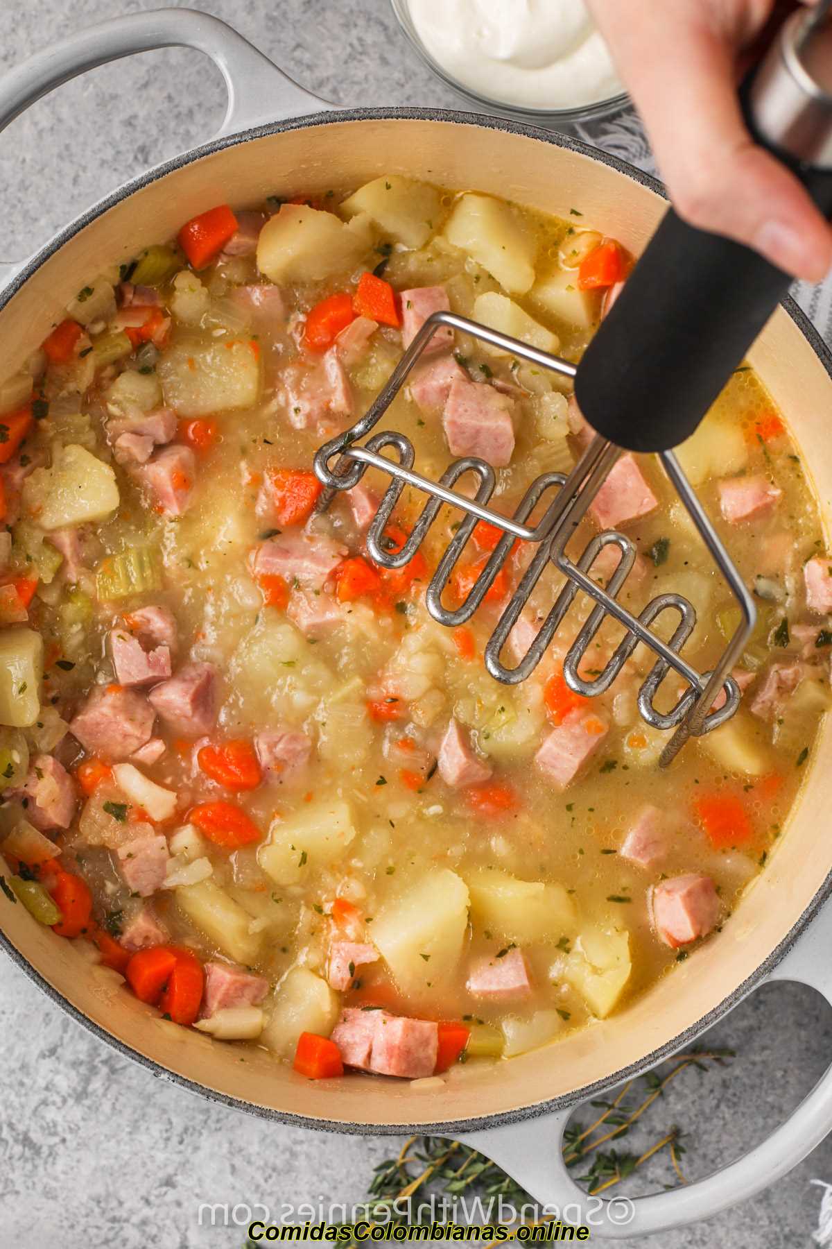un triturador en una olla de jamón y sopa de patata