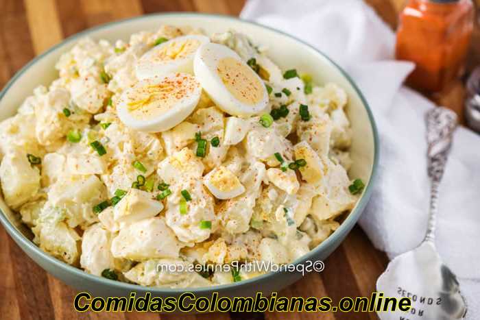 Ingredienti per l'insalata di patate con uovo alla diavola in una ciotola con un cucchiaio da portata