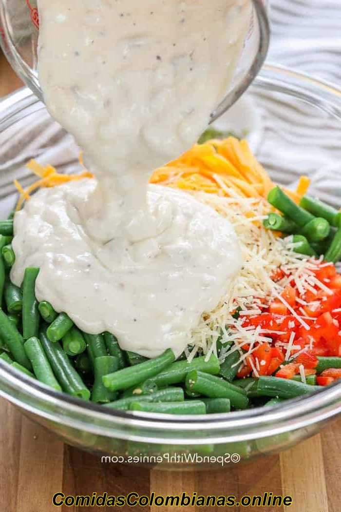 Verter la salsa de champiñones sobre los ingredientes de la cazuela de judías verdes