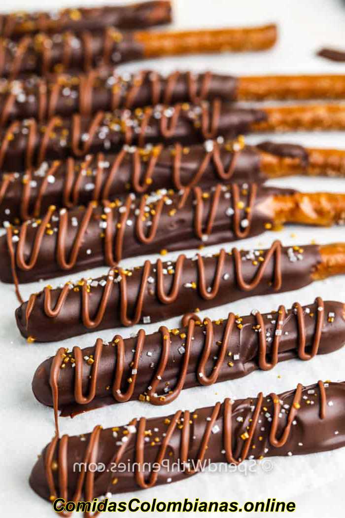 Primer plano de pretzels cubiertos de chocolate con caramelo decorados en papel pergamino