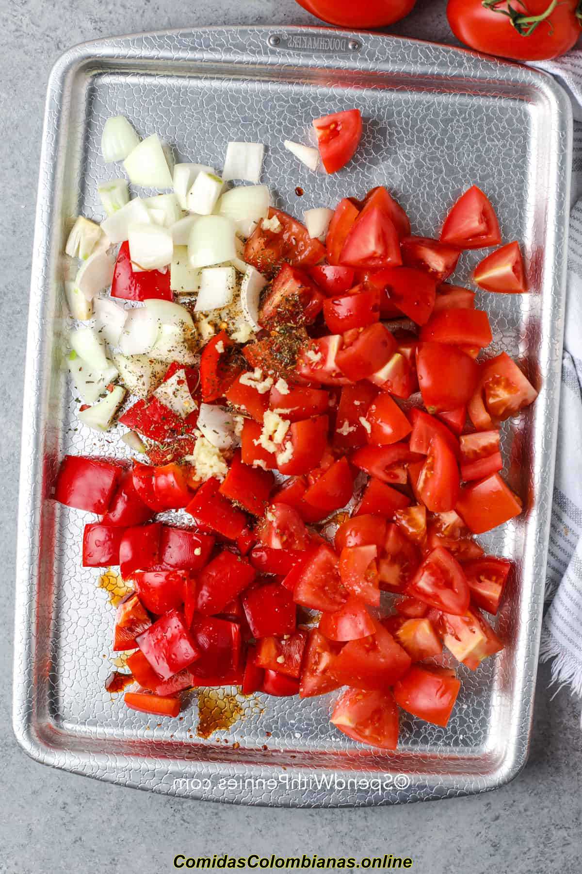 agregando condimentos a los tomates y la cebolla para hacer sopa Kielbasa