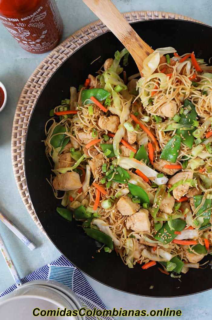 Chow mein de pollo en un bol con una cuchara de madera